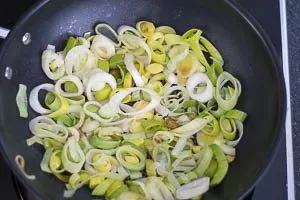 Frischer Lauch wird in der Pfanne sanft angedünstet, Basis für die Sahnesoße.