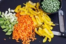 Frisches, geschnittenes Gemüse für gebratenen Reis: Karottenwürfel, Paprikastreifen und Frühlingszwiebeln