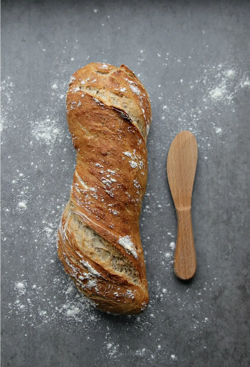 Frisches Sauerteigbrot selber backen auf einem Holzbrett, perfekt für die deutsche Brotkultur.