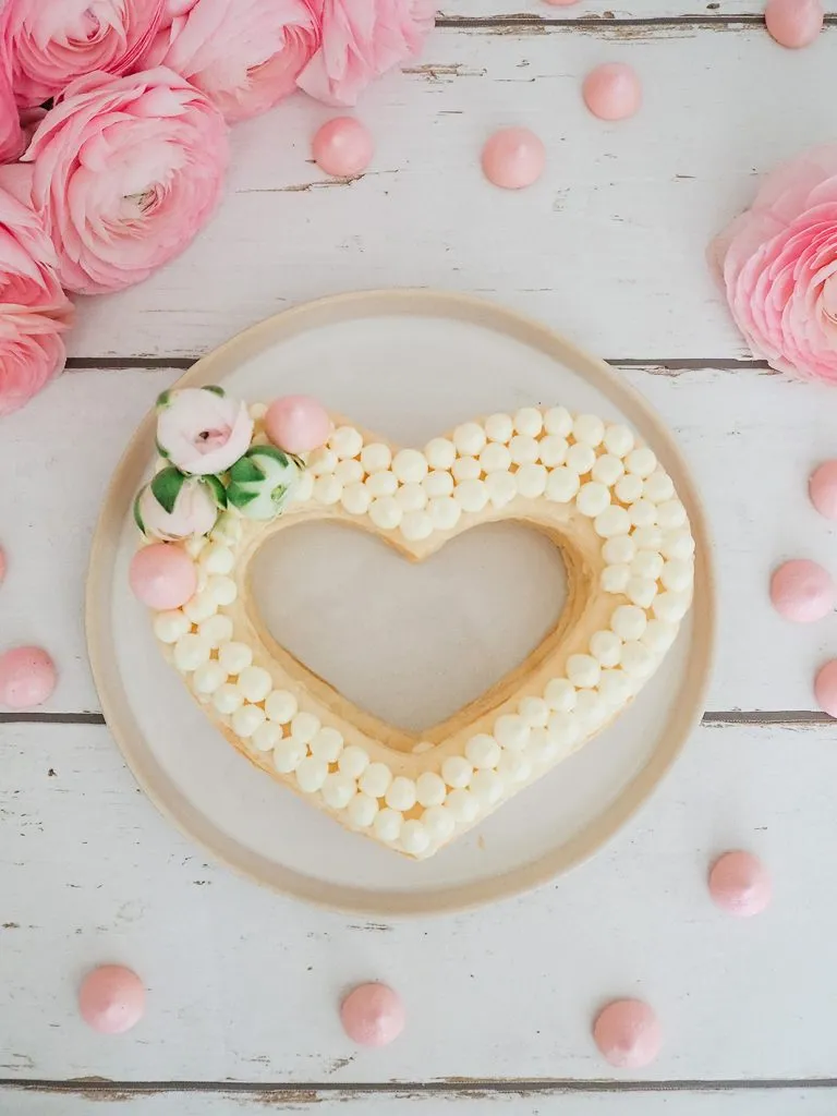 Frischkäse-Frosting wird auf die Blätterteigherzen gespritzt