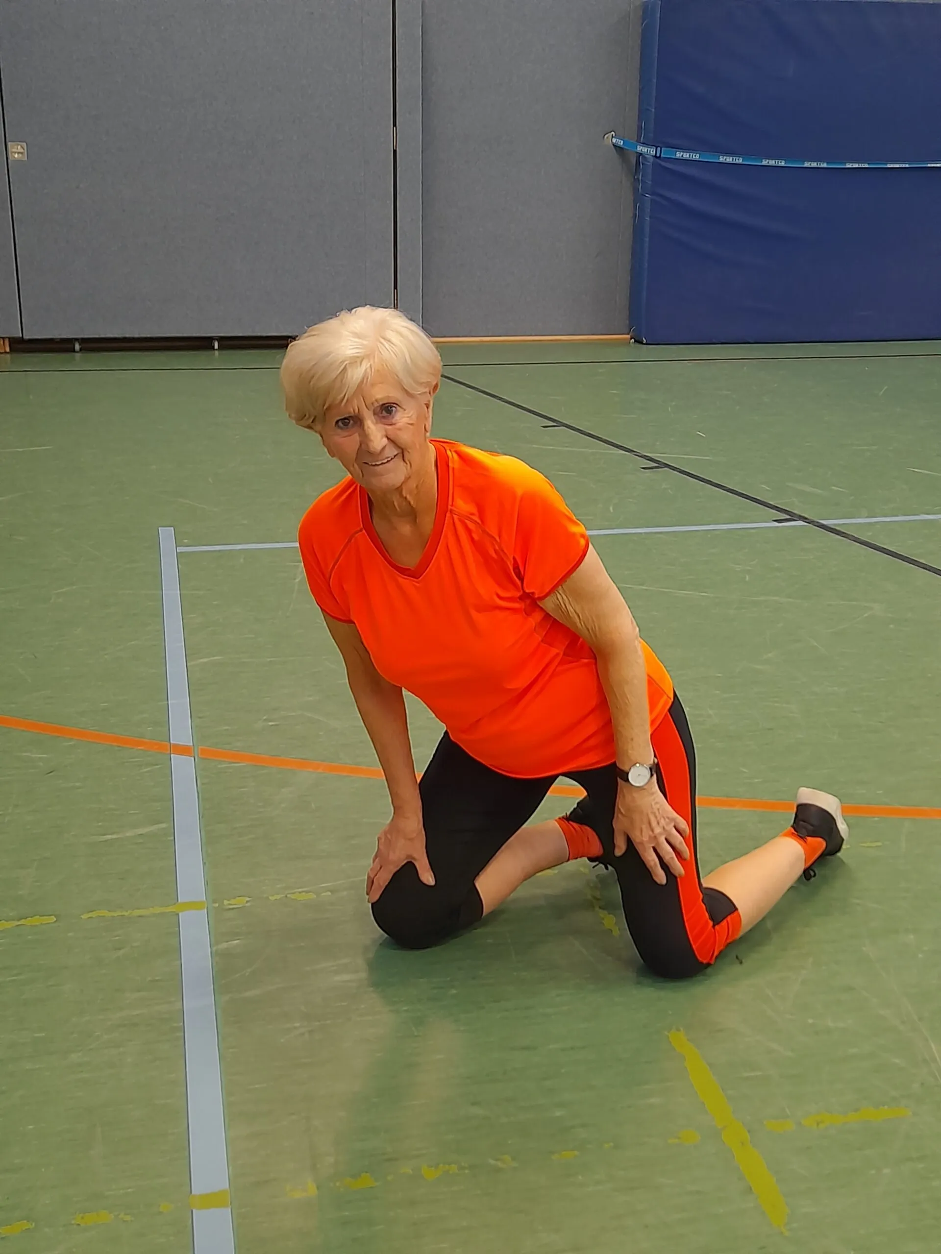 Fröhliche Kleinkinder beim Kinderturnen ab 3 Jahren in einer Sporthalle, die spielerisch motorische Fähigkeiten und Gleichgewicht trainieren.