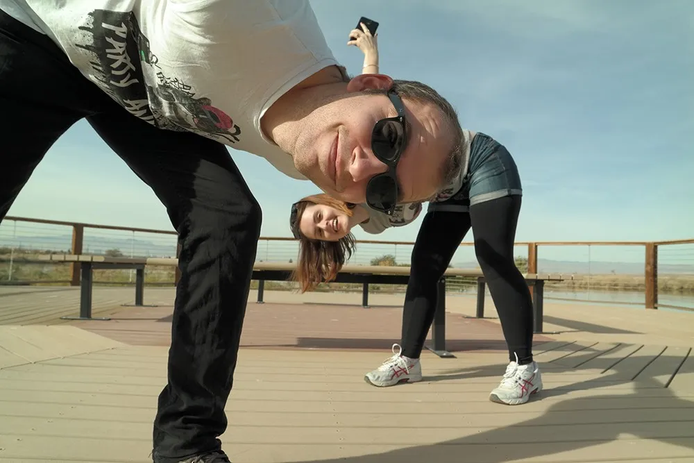 Fröhliche Person posiert mit Sonnenbrille, symbolisiert Reisefreude und gute Laune