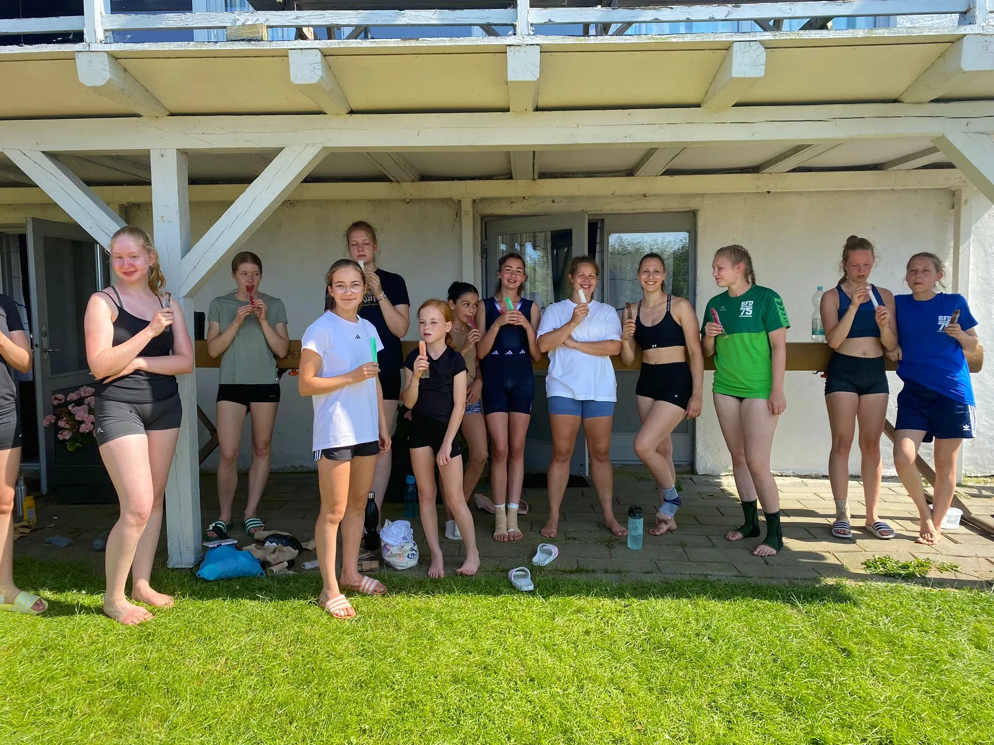 Fröhliche Turnerinnen und Trainer bei einer Aktivität während des Trainingslagers in Dänemark