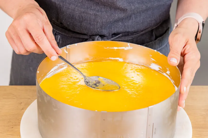 Fruchtspiegel gleichmäßig auf Pfirsich Joghurt Sahne Torte auftragen