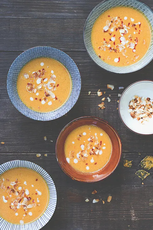 Fünf Schalen scharfe Kürbis-Erdnuss-Suppe, garniert mit Kokoschips