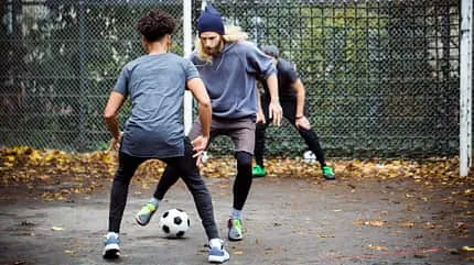 Fußballspieler auf dem Rasen in Aktion, dynamischer Ausgleichssport