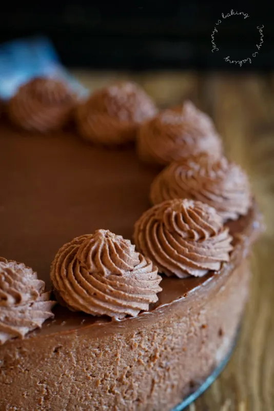 Ganache-Schicht auf einem fertig gekühlten No-Bake Schoko-Cheesecake in der Springform, bereit zum Dekorieren