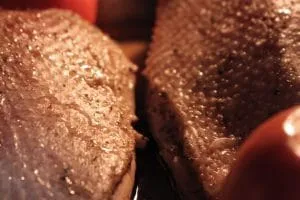 Gänsebrust brät langsam im Ofen, übergossen mit Flüssigkeit aus dem Bräter