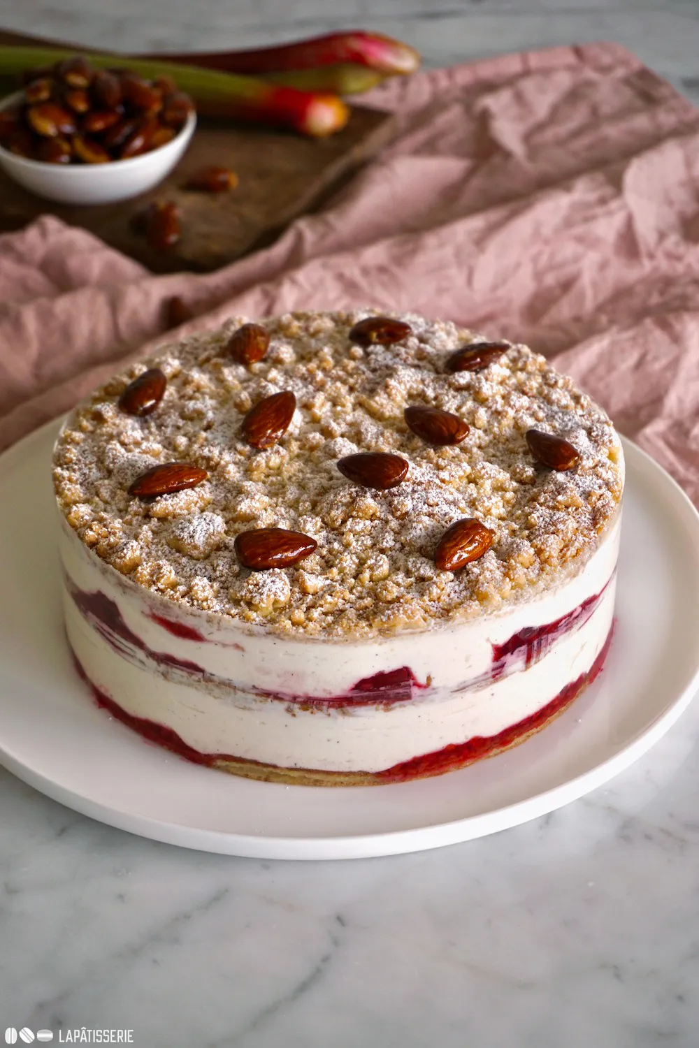 Ganze Flockensahnetorte mit Puderzucker bestäubt, Rhabarber-Himbeer-Füllung