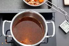 Garsud wird durch ein Sieb in einen Topf abgegossen