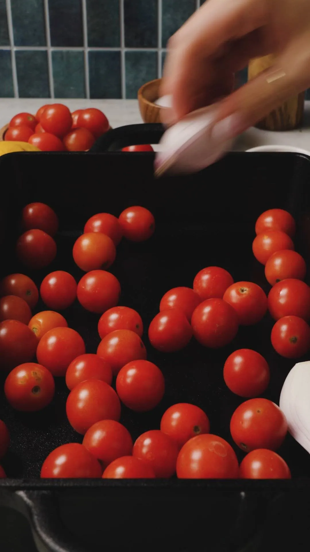 gebackener feta in einer pfanne mit gerösteten kirschtomaten und schalotten