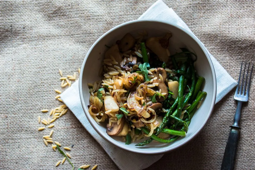Gebratene Mairübchen, Pilze und Spargel in einer Pfanne, bereit zum Ablöschen mit Sherry