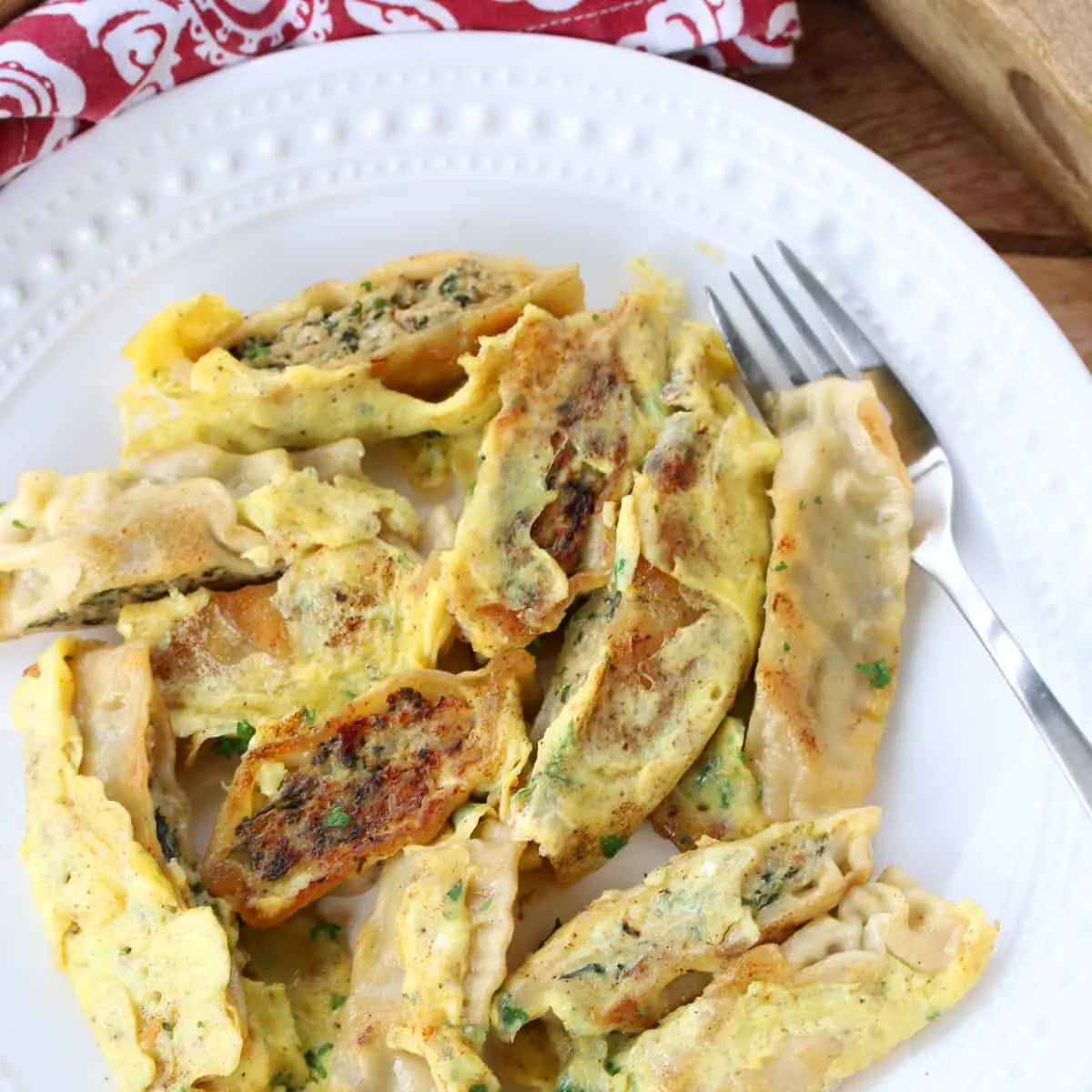 gebratene maultaschen mit ei und kräutern in der pfanne