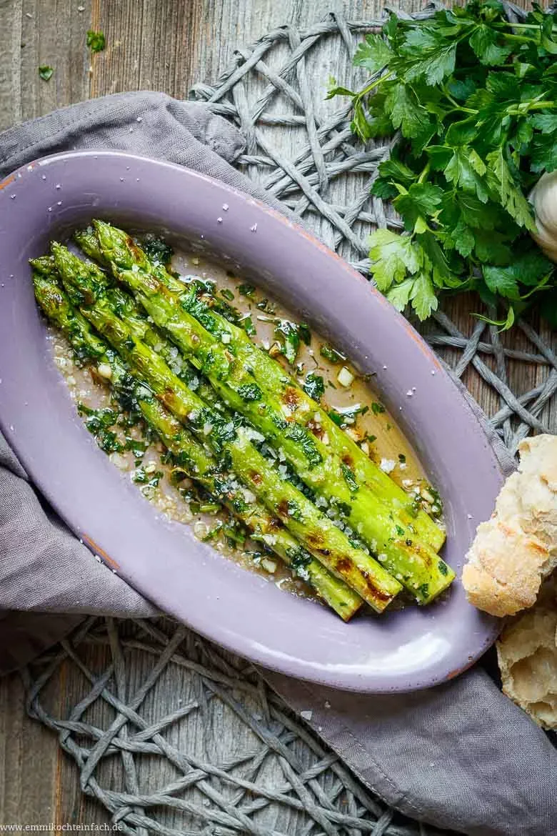 Gebratener grüner Spargel mit Kräutern und Gewürzen auf einem Teller