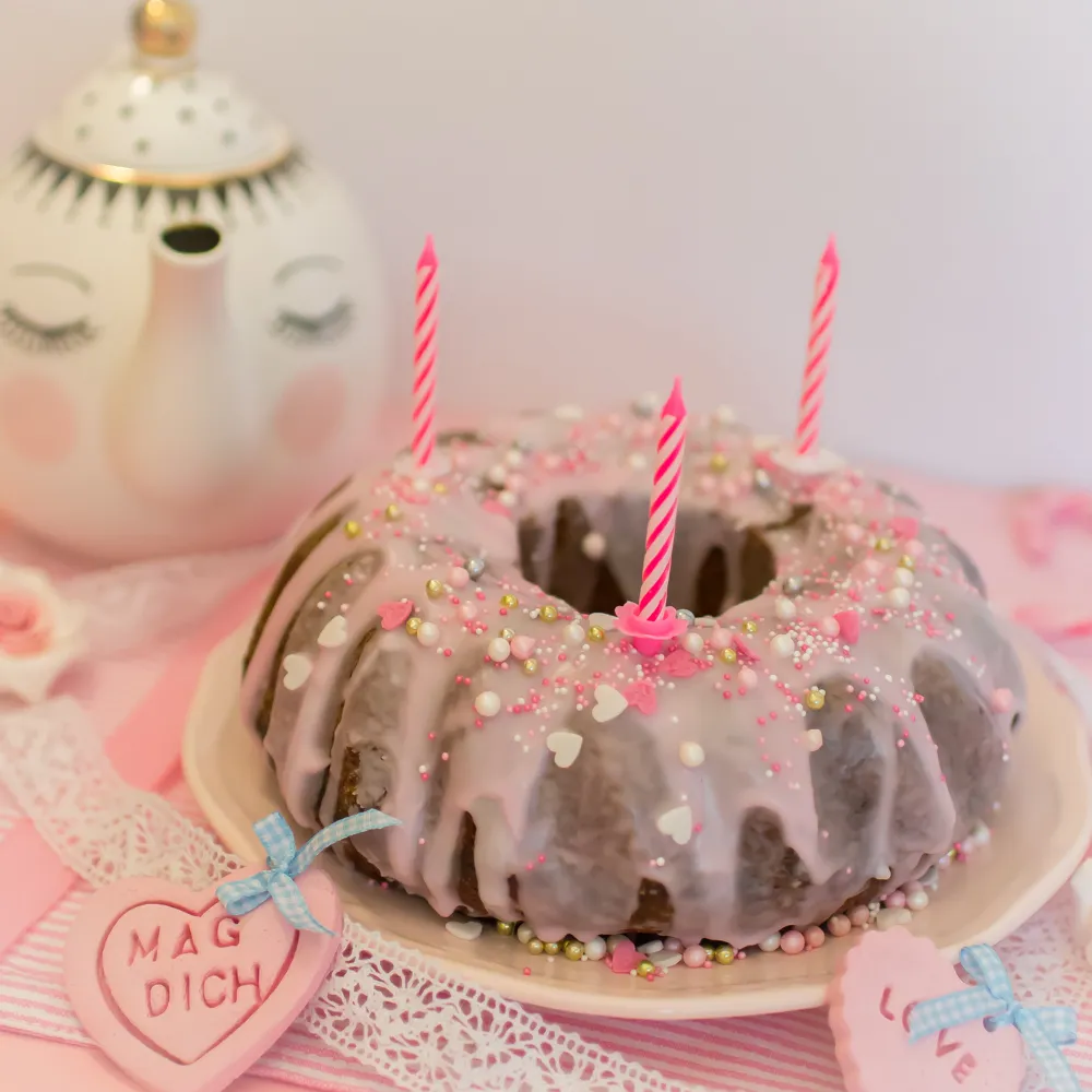 Geburtstagskuchen mit Zuckerguss und Streuseln auf einem Backblech