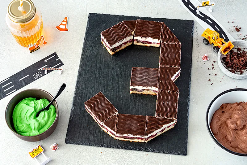 Geburtstagszahl aus Kuchenstücken für den Bagger Geburtstagskuchen formen