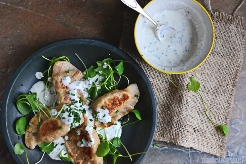 Geformte Pierogi vor dem Kochen, die die handwerkliche Zubereitung der Teigtaschen zeigen.