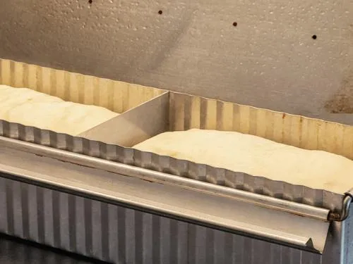 Geformter Toastbrotteig in einer geschlossenen Backform vor dem Backen