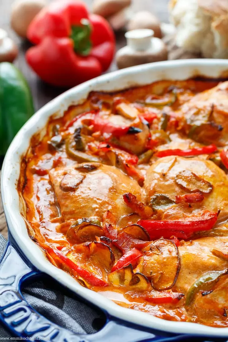 Gefüllte Auflaufform mit roher Hähnchenbrust und zubereiteter Soße