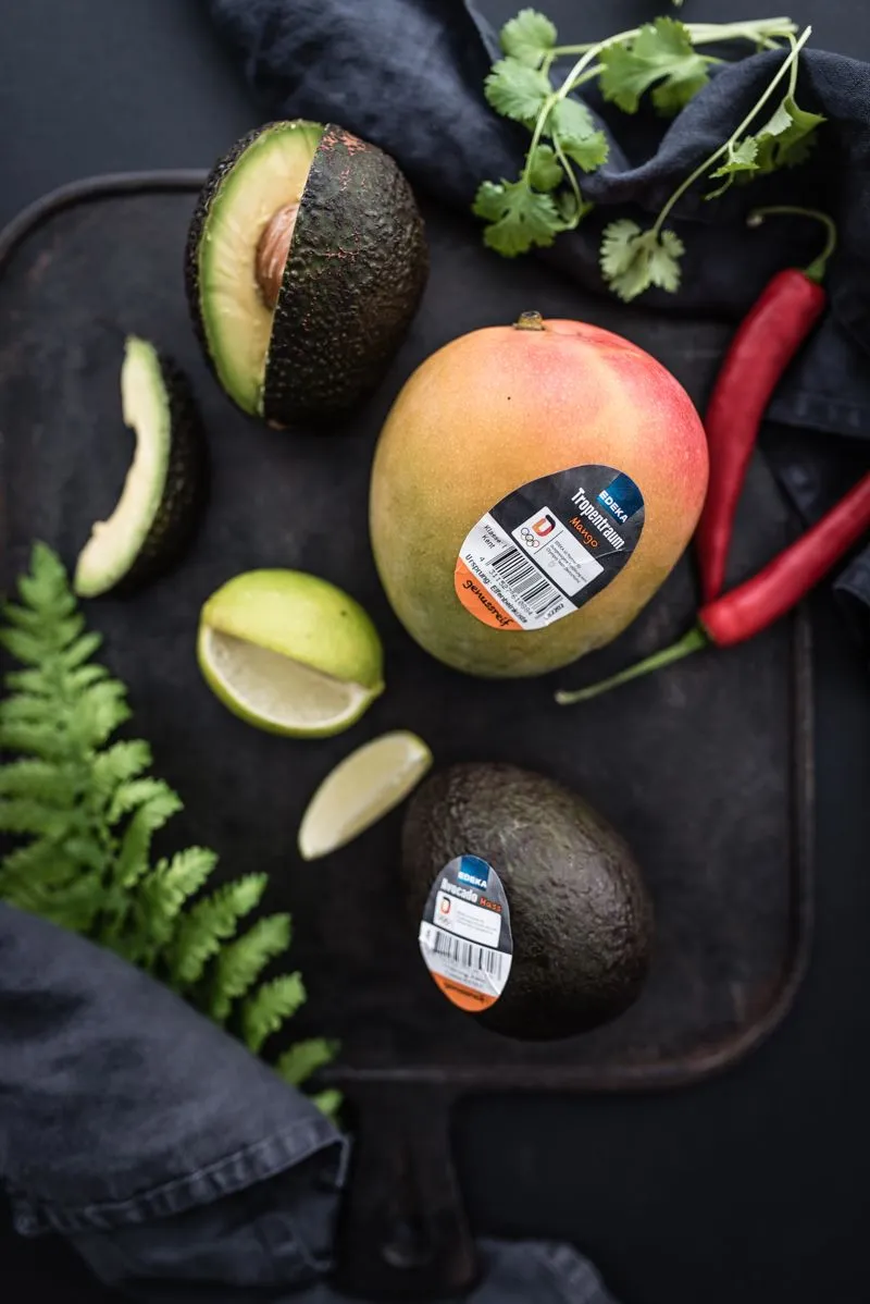 Gegrilltes Thunfischsteak mit Mango-Avocado-Salsa und grünem Spargel auf einem Teller