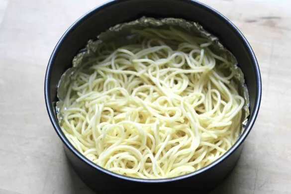 Gekochte Spaghetti werden in eine Springform gegeben