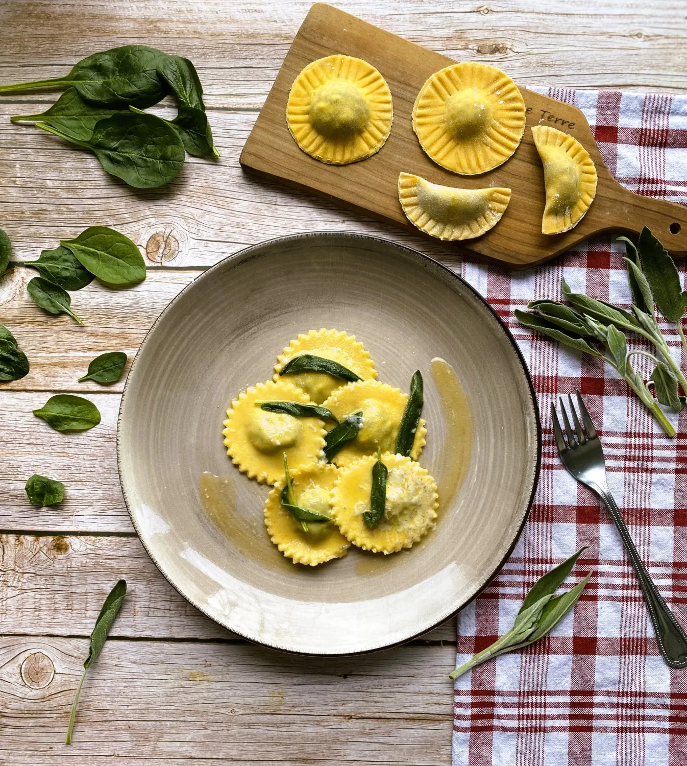 Gekochte Spinat-Ricotta-Ravioli werden in Salbeibutter geschwenkt, eine klassische Zubereitungsart für selbstgemachte Pasta.