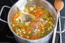 Gemüse kocht in Brühe mit Gewürz-Ei in einem Topf, ein wesentlicher Schritt beim Suppe kochen für Anfänger, um Geschmack zu entwickeln.