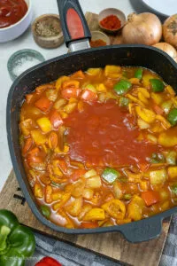 Gemüse mit Soße im Topf, bereit für den Ofen.