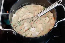 Gemüse und Sahne köcheln in der cremigen Soße für Hühnerfrikassee