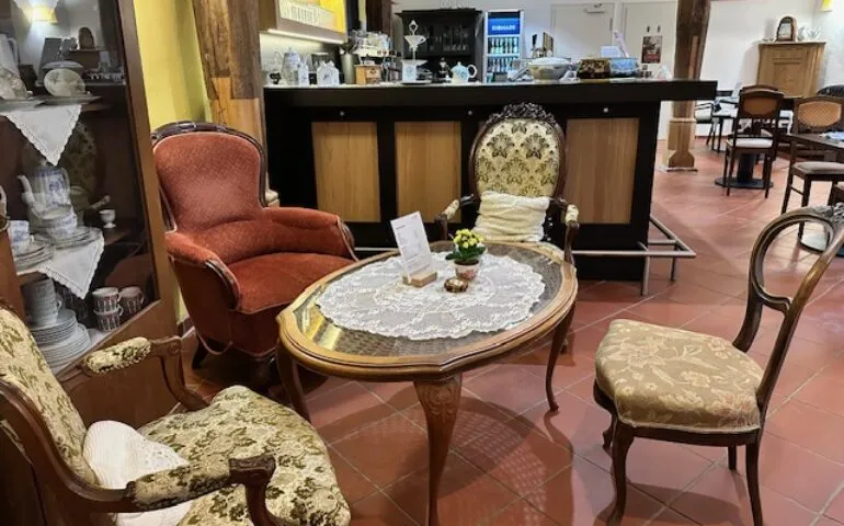 Gemütlicher Innenraum des Café Kranich mit Holztischen, bunten Stühlen und liebevoller Dekoration