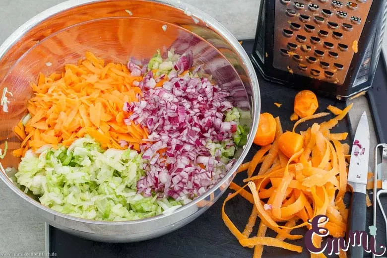 Geriebenes Gemüse für Coleslaw: Möhren und fein gewürfelte Zwiebeln