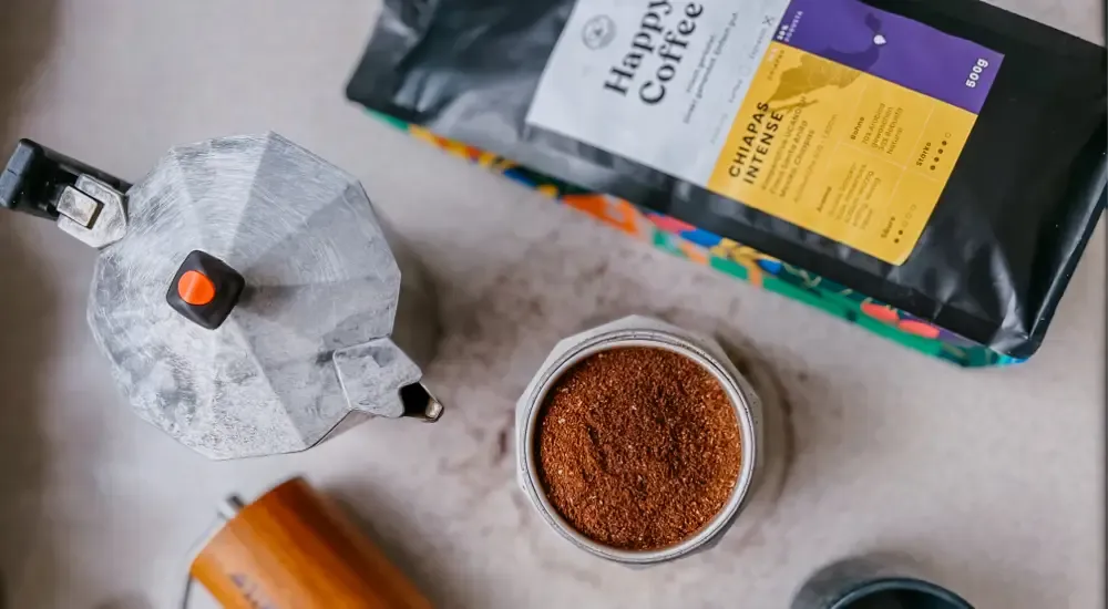 Geröstete Espressobohnen und eine Packung &quot;Happy Coffee Chiapas Intense&quot; für den italienischen Kaffeekocher