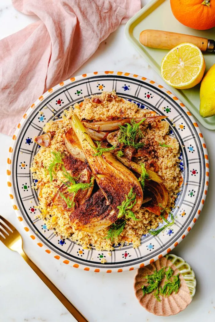 Geschmorter Fenchel mit karamellisierten Rändern und frischem Zitronen-Couscous auf einem weißen Teller