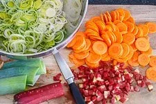 Geschnittenes Gemüse wie Lauch und Karotten in einer Schüssel, bereit für die Zubereitung einer einfachen Suppe für Anfänger.