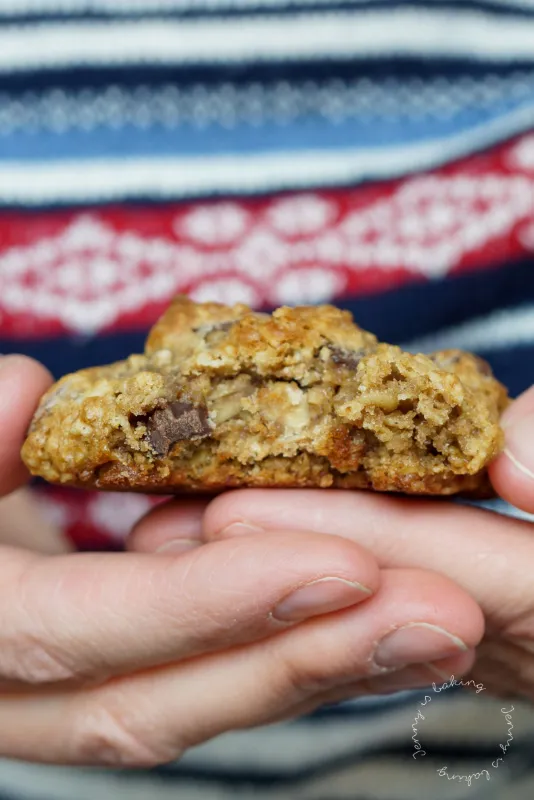 Gestapelte goldbraune Haferflockenkekse mit dunkler Schokolade auf einem Holzbrett