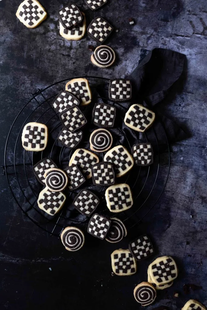 Gestapelte Scheiben von Schwarz-Weiß-Gebäck, das ein präzises Schachbrettmuster aus Vanille- und Schokoladenteig zeigt