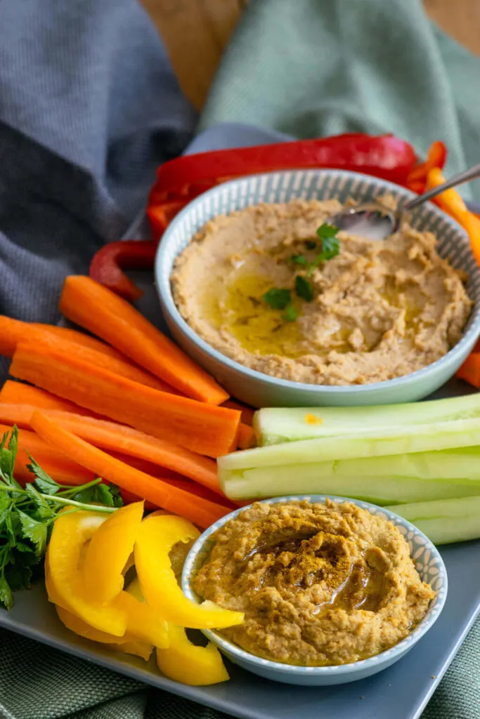 Gesunde Rohkost-Sticks mit cremigem Hummus, passend zum selbstgebackenen Brot