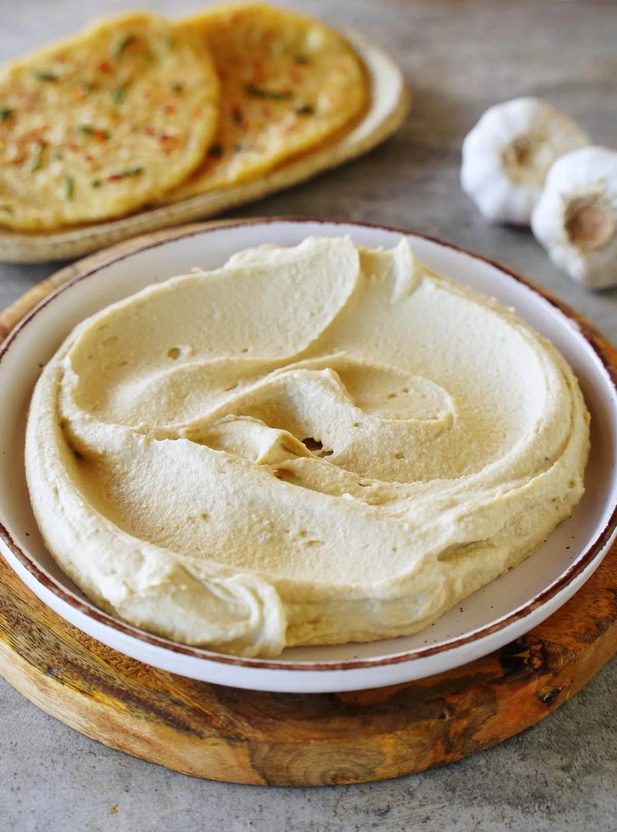 Gesunder, ölfreier Hummus ohne Garnitur auf einem Teller, die perfekte Basis für individuelle Kreationen