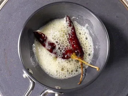 Getrocknete rote Chilis in Ghee für das knisternde Tadka braten