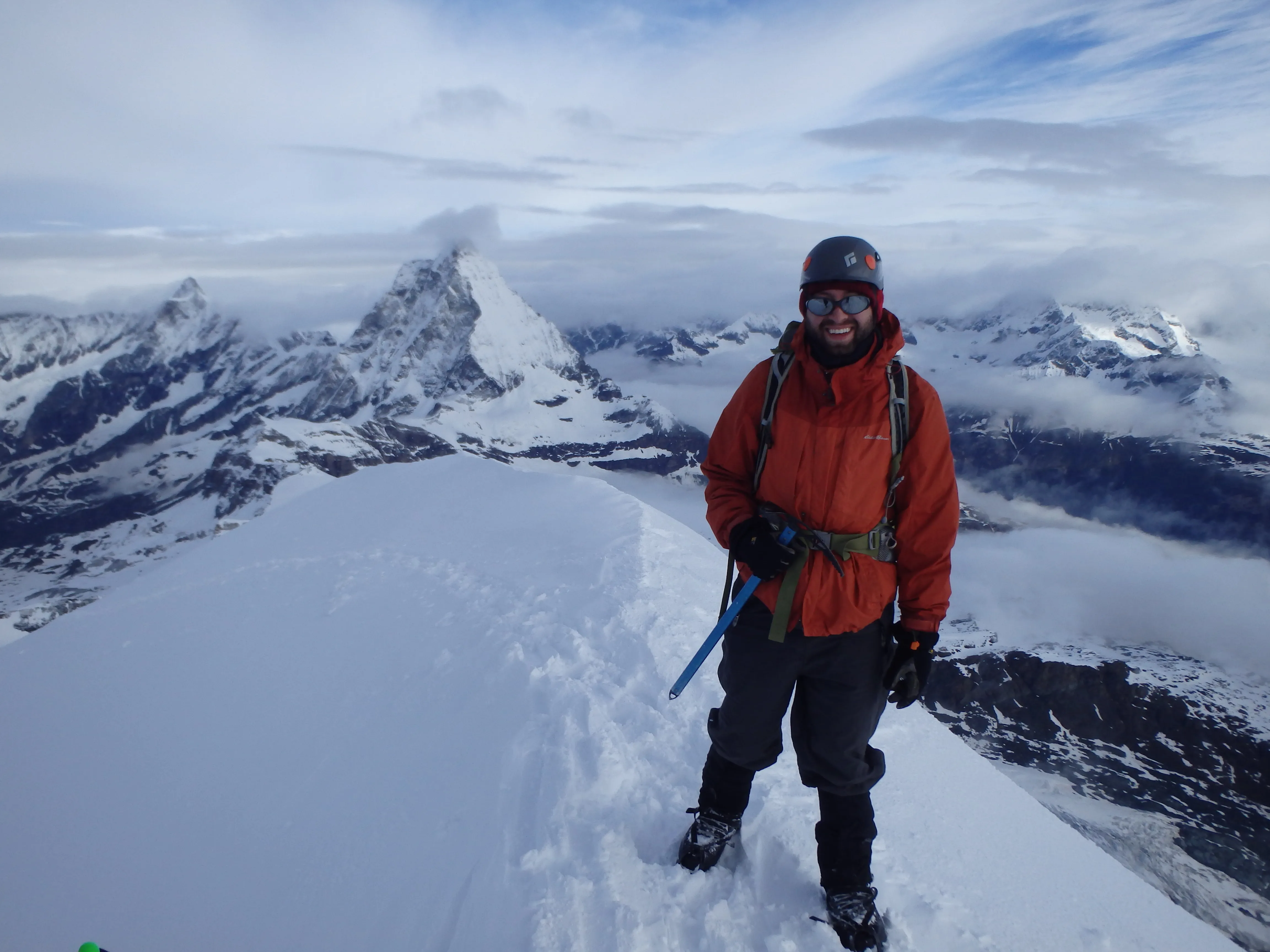 Gipfelfoto mit dem Matterhorn in der Ferne, zentral im Bild