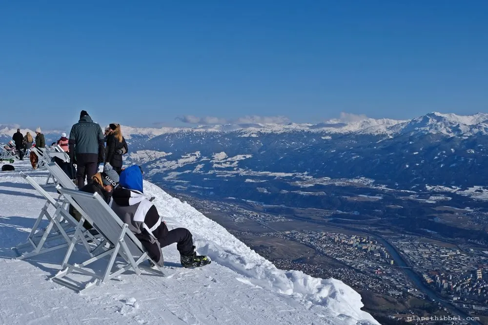 Gipfelkreuz im Schnee vor beeindruckendem Alpenpanorama