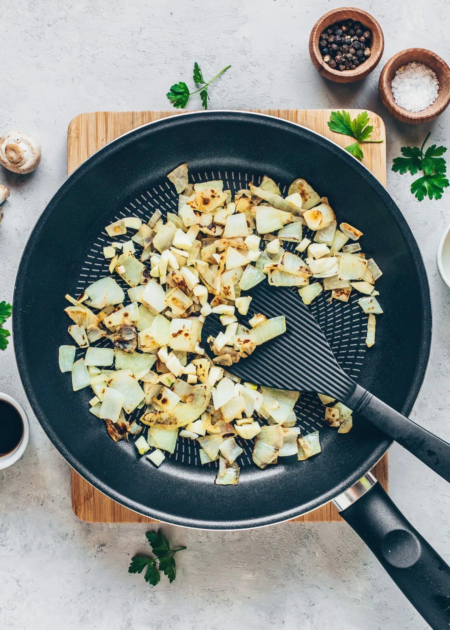 glasig gedünstete Zwiebelwürfel in einer Pfanne für die Hackbällchenmasse