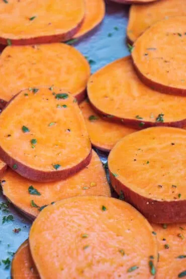 Gleichmäßig marinierte Süßkartoffeltaler liegen bereit, um auf dem Grillrost platziert zu werden und perfekt zu garen.