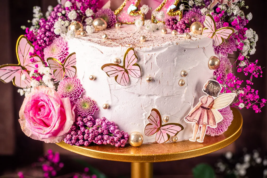 Glitzernde Streusel und goldene Perlen als Feenstaub auf dem Geburtstagskuchen