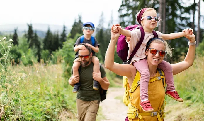 Glückliche Familie bei einer Wanderung, abgesichert durch Risikolebensversicherung Generali