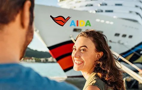 Glückliche Frau genießt eine AIDA Kreuzfahrt an Deck des Schiffes mit Blick auf das Meer