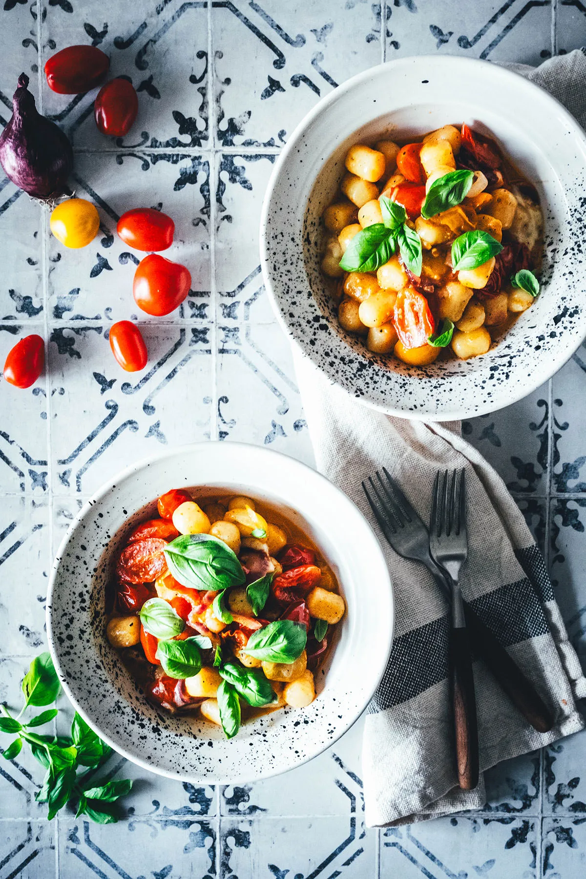 Gnocchi-Pfanne mit Tomaten und Mozzarella, serviert mit frischem Basilikum.