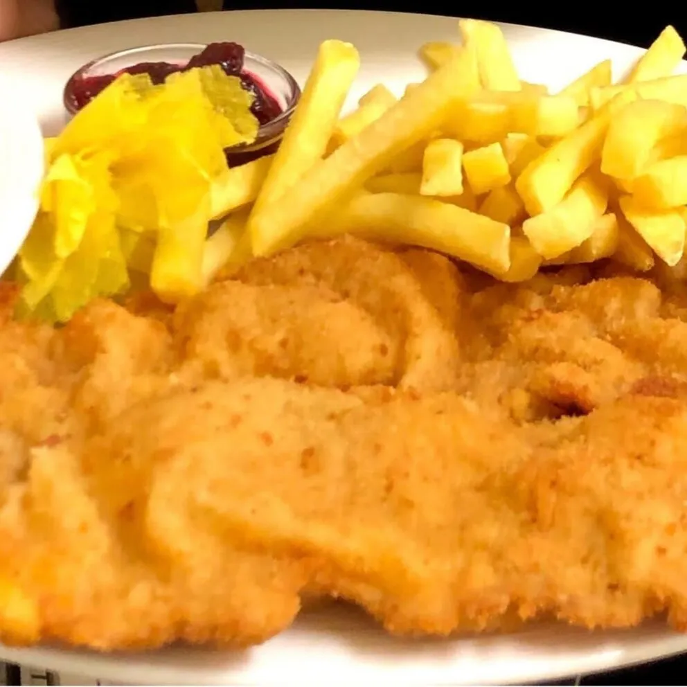 Goldbraun gebackenes Wiener Schnitzel vom Kalb, klassisch serviert mit Petersilienkartoffeln oder Pommes