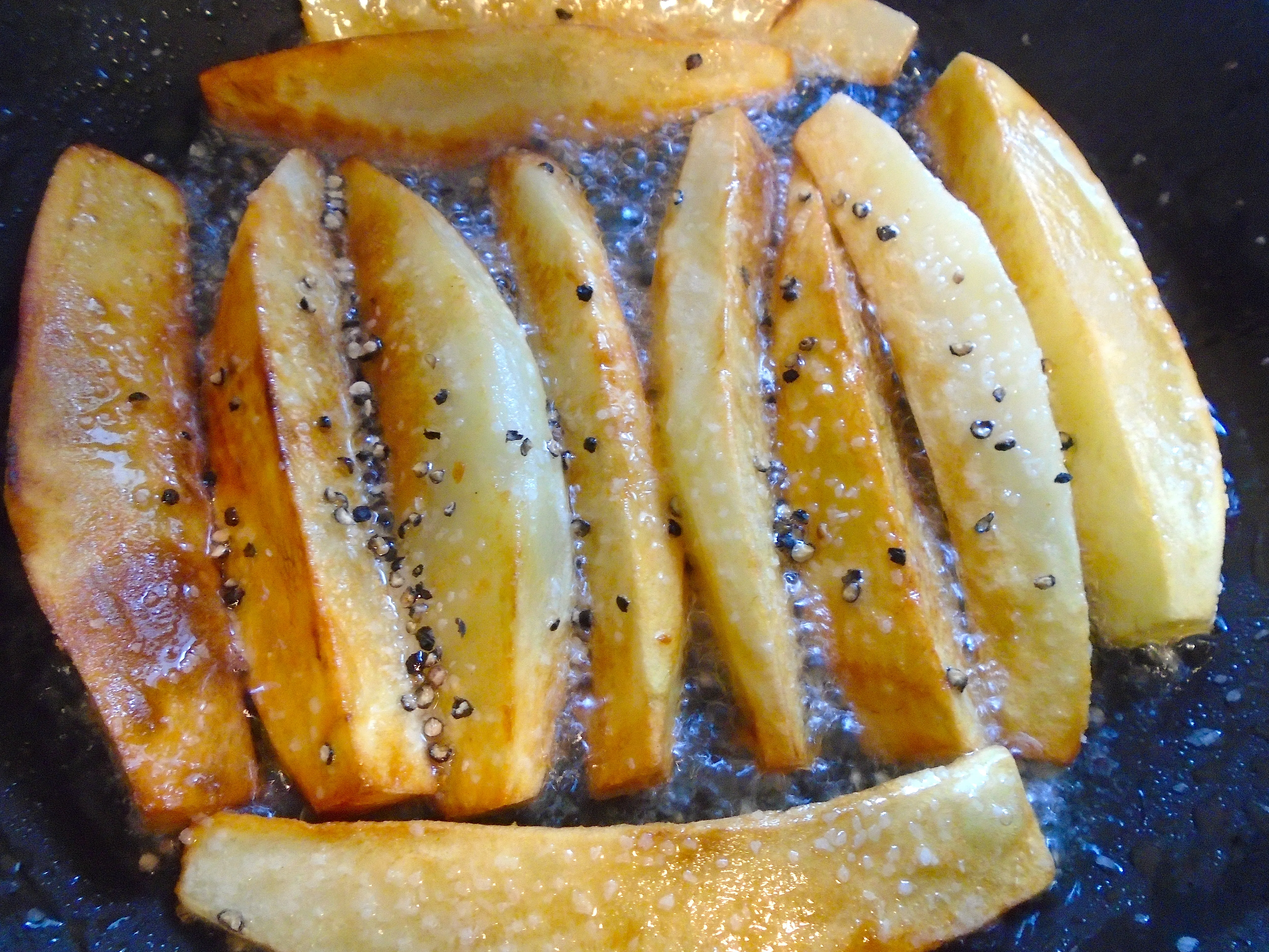 Goldbraun gebratene Kartoffeln, gewürzt mit Salz und Pfeffer, als Beilage zu Schälrippchen