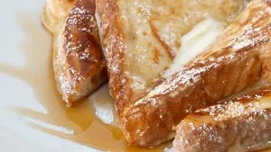 Goldbraun gebratener French Toast, bestrichen mit Honig oder Ahornsirup